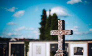 Steinkreuz in einem Friedhof.